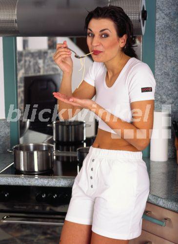 Junge Frau in der Kueche, kostet Nudeln<BR>woman in the kitchen - allOver/TPH