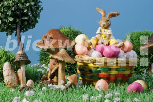 blickwinkel Osterhase auf einem Korb voller Ostereier blickwinkel Osterhase auf einem Korb voller Ostereier
