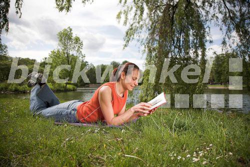 blickwinkel Frau liegt im Park auf einer Wiese und liest blickwinkel Frau liegt im Park auf einer Wiese und liest