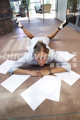 junge Geschaeftsfrau ist ueber der Arbeit zusammengebrochen und liegt mit losen Blaettern am Boden<BR>young dropped businesswoman lying with several chits of paper on the floor - McPHOTO junge Geschaeftsfrau ist ueber der Arbeit zusammengebrochen und liegt mit losen Blaettern am Boden<BR>young dropped businesswoman lying with several chits of paper on the floor - McPHOTO
