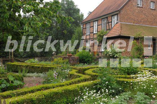 blickwinkel - Bauerngarten im Hof eines alten Hauses aus rotem